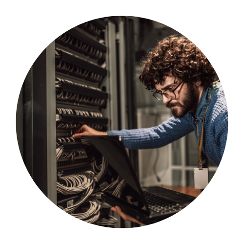 Individual working in a server room, engaging with numerous cables connected to a rack of network equipment. The person is wearing a blue sweater and is focused on adjusting or organizing the cables.

Mission Control NOC and HelpDesk, NOC Services, SLA, MSP, Outsources MSP, MSP Services